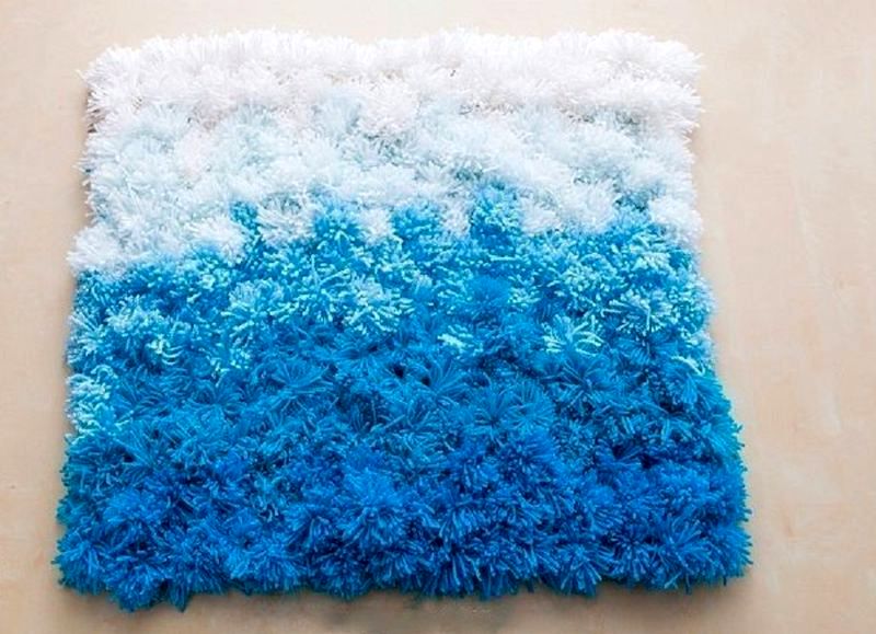 niebiesko-biały dywanik z pomponem