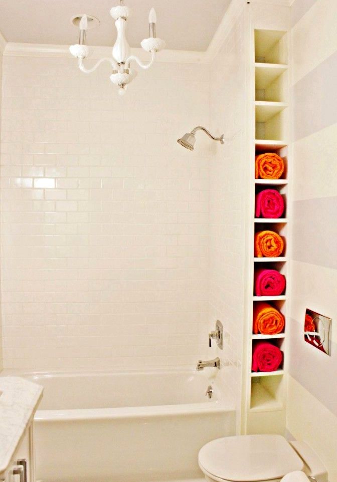 узкие полки для хранения полотенец за стенкой ванной комнаты