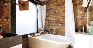 ванна кімната в індустріальному стилі з цегляною стіною